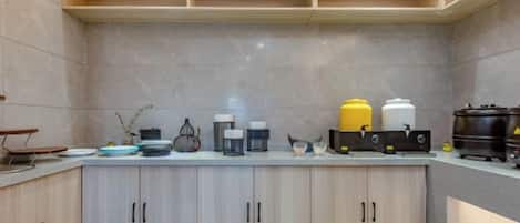 A kitchen with a countertop, cabinets, and various appliances.