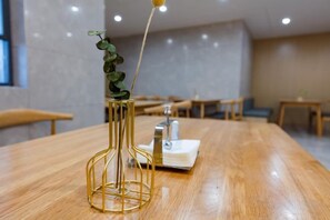 A wooden table with a gold vase containing a plant. - GYA Hotel (Jiaxing Nanhu Scenic Area Nanhu Tiandi) (Jiaxing)