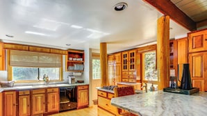 A spacious kitchen with wooden cabinets, a marble countertop, and a large window providing natural light. - 3 Mi to Ski Slopes: Park City Retreat w/ Game Room (Park City)