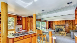 A wooden cabin interior with a kitchen, dining area, and fireplace. - 3 Mi to Ski Slopes: Park City Retreat w/ Game Room (Park City)