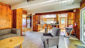A spacious living area with a sofa, armchair, and coffee table. A kitchen with wooden cabinets and a dining area with a table and chairs are visible. - 3 Mi to Ski Slopes: Park City Retreat w/ Game Room (Park City)