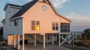 A white wooden building with a gabled roof and a circular sign on the front. - Gorgeous/Great Gulf Views! (Gulf Shores)