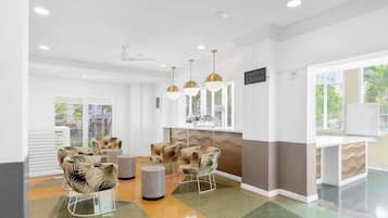 Uma área de espera moderna com assentos confortáveis, um espaço para café e vista para o exterior.
