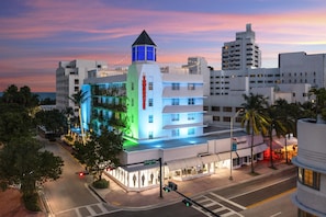 A hotel with a prominent tower, Collins Ave address, and a street view with traffic lights.