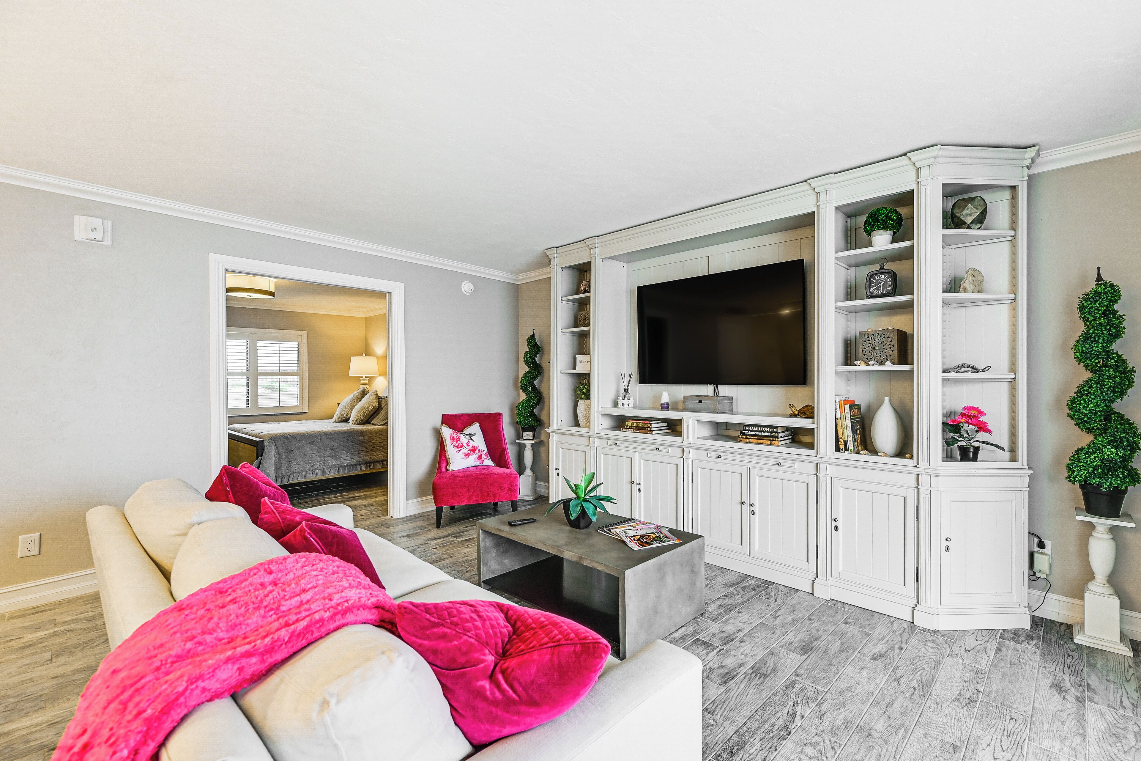 A living room with a sofa, coffee table, and a TV on a cabinet.