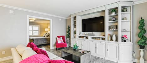 A living room with a sofa, coffee table, and a TV on a cabinet.