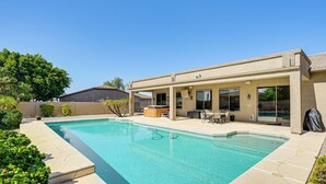 A rectangular swimming pool with a tiled deck, surrounded by a covered patio area with outdoor furniture. - Hot Tub & On-site Hiking: Phoenix Retreat! (Phoenix)