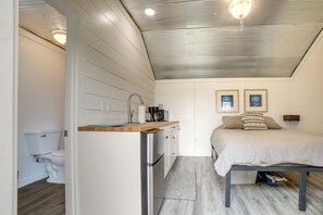 A compact room with a kitchenette, a bed, and a small bathroom. - Dumont Lake Studio: Boat, Fish & Unwind! (Allegan)