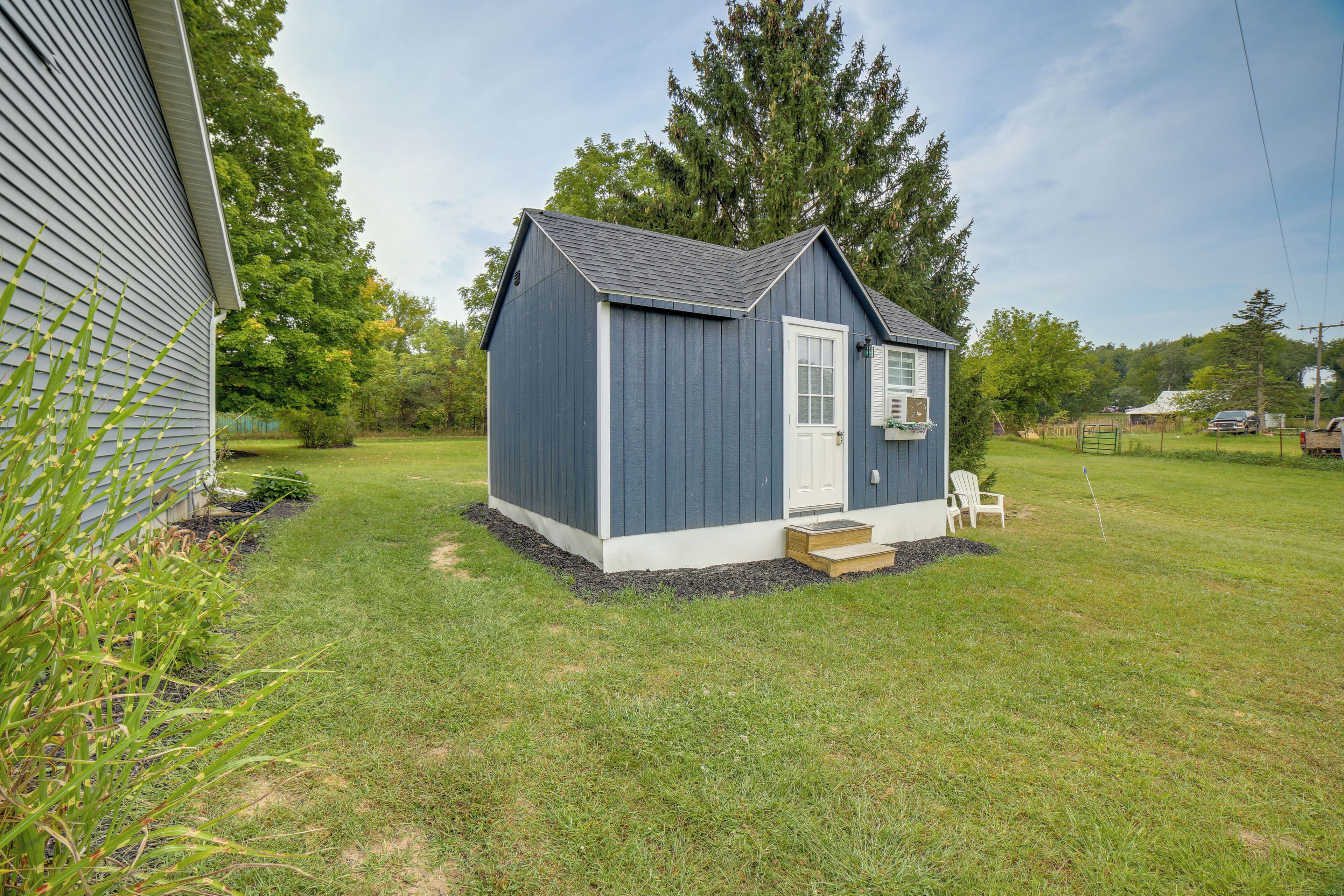 A small, single-story shed with a white door and a small porch.