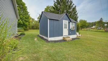 A small, single-story shed with a white door and a small porch.