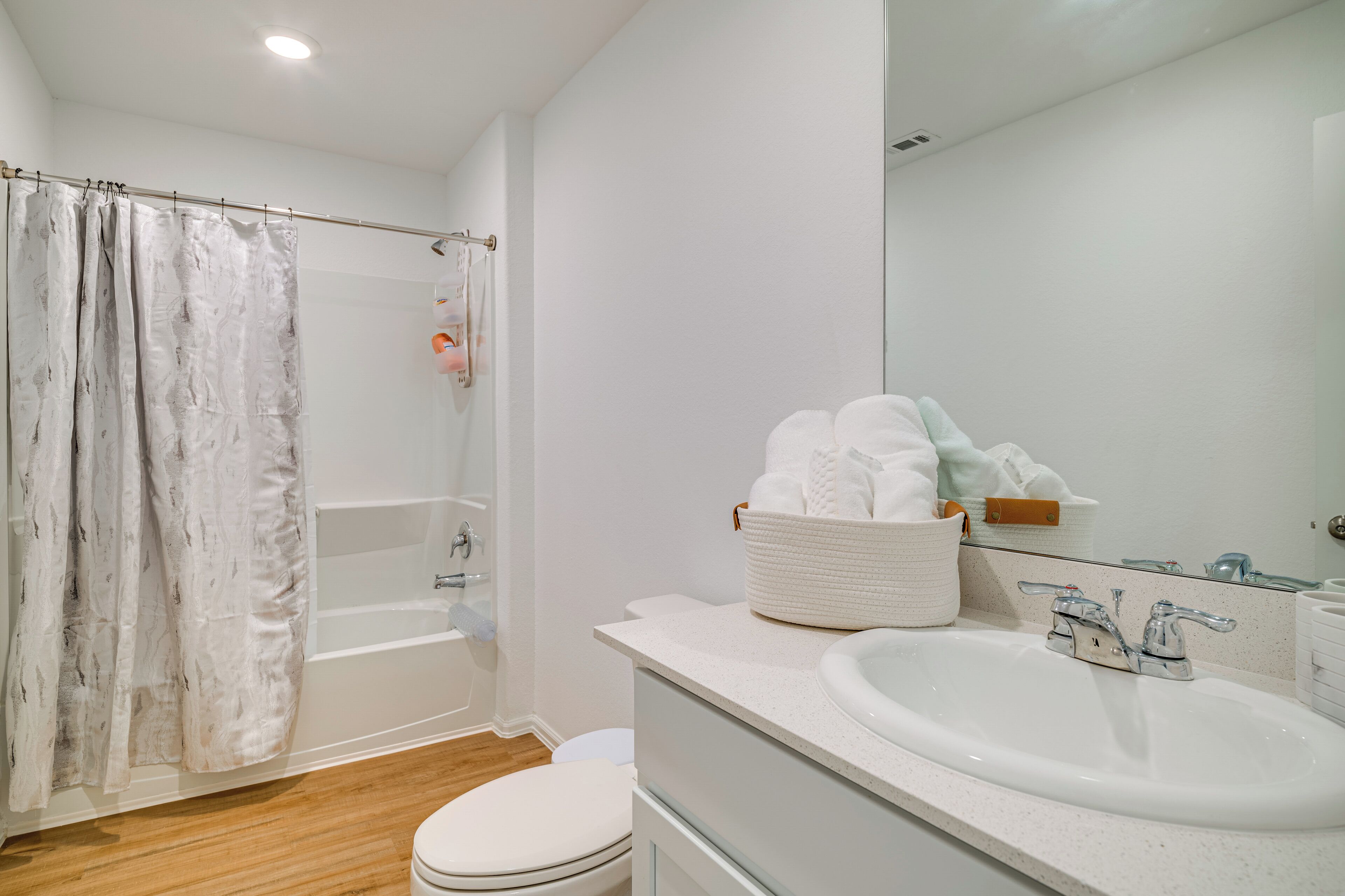 A modern bathroom with a bathtub, toilet, and sink.