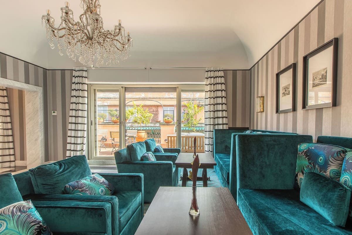 Una sala de estar moderna con sofás color turquesa, una mesa de centro de madera y un candelabro.