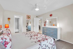 A bedroom with a bed, dresser, mirror, and ceiling fan. - H-247 - Second Floor With Lake and Fountain View (Naples)