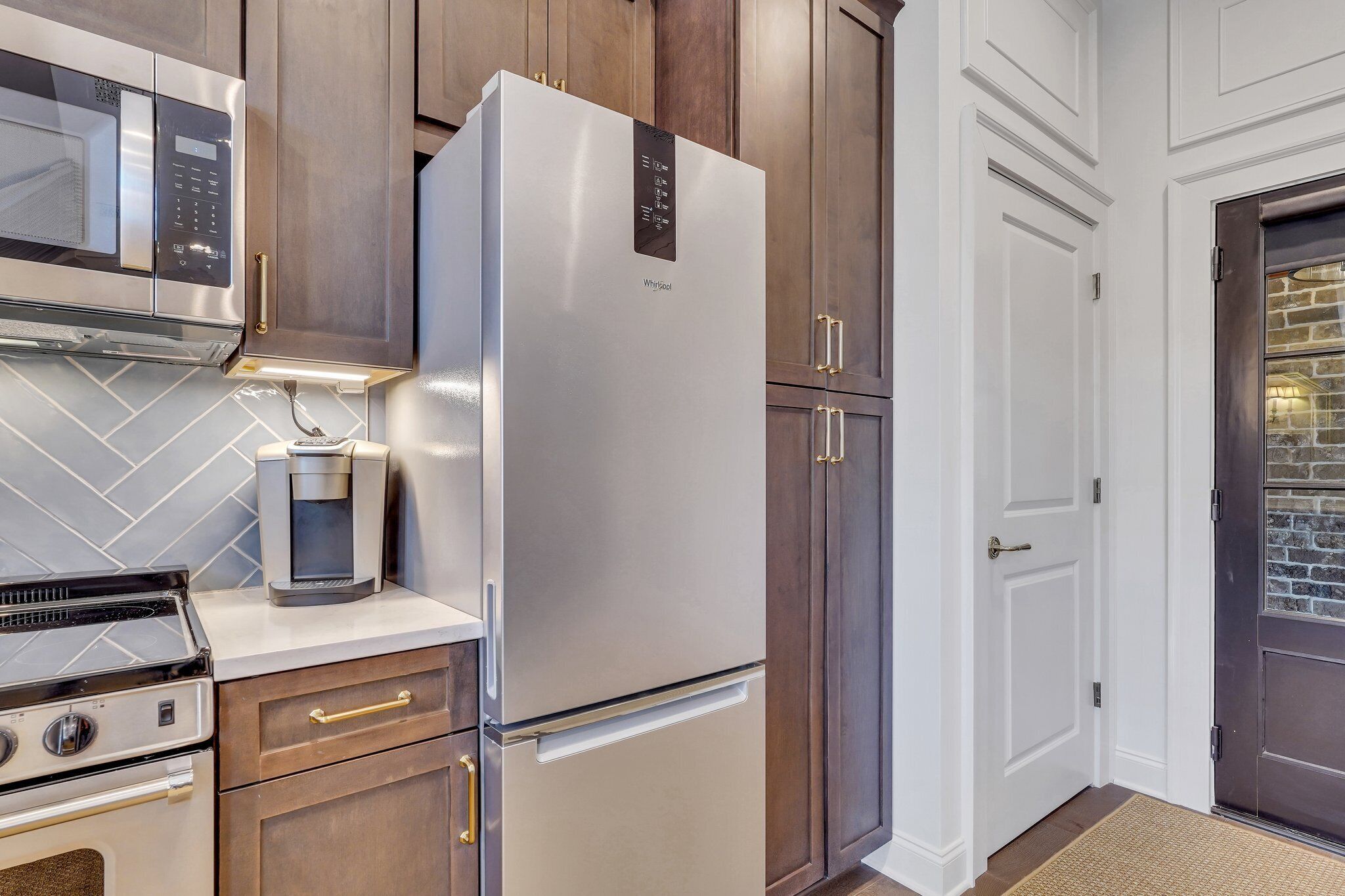 A kitchen with a stainless steel refrigerator, a coffee maker, and a microwave.