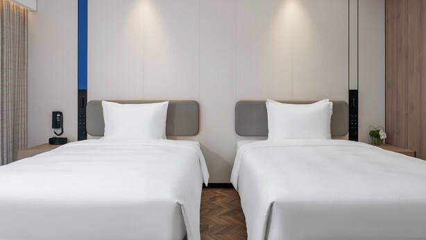 A hotel room with two beds, a phone on the nightstand, and a small plant on the nightstand. - Holiday Inn Express Chengdu Shuangliu Airport (Chengdu)