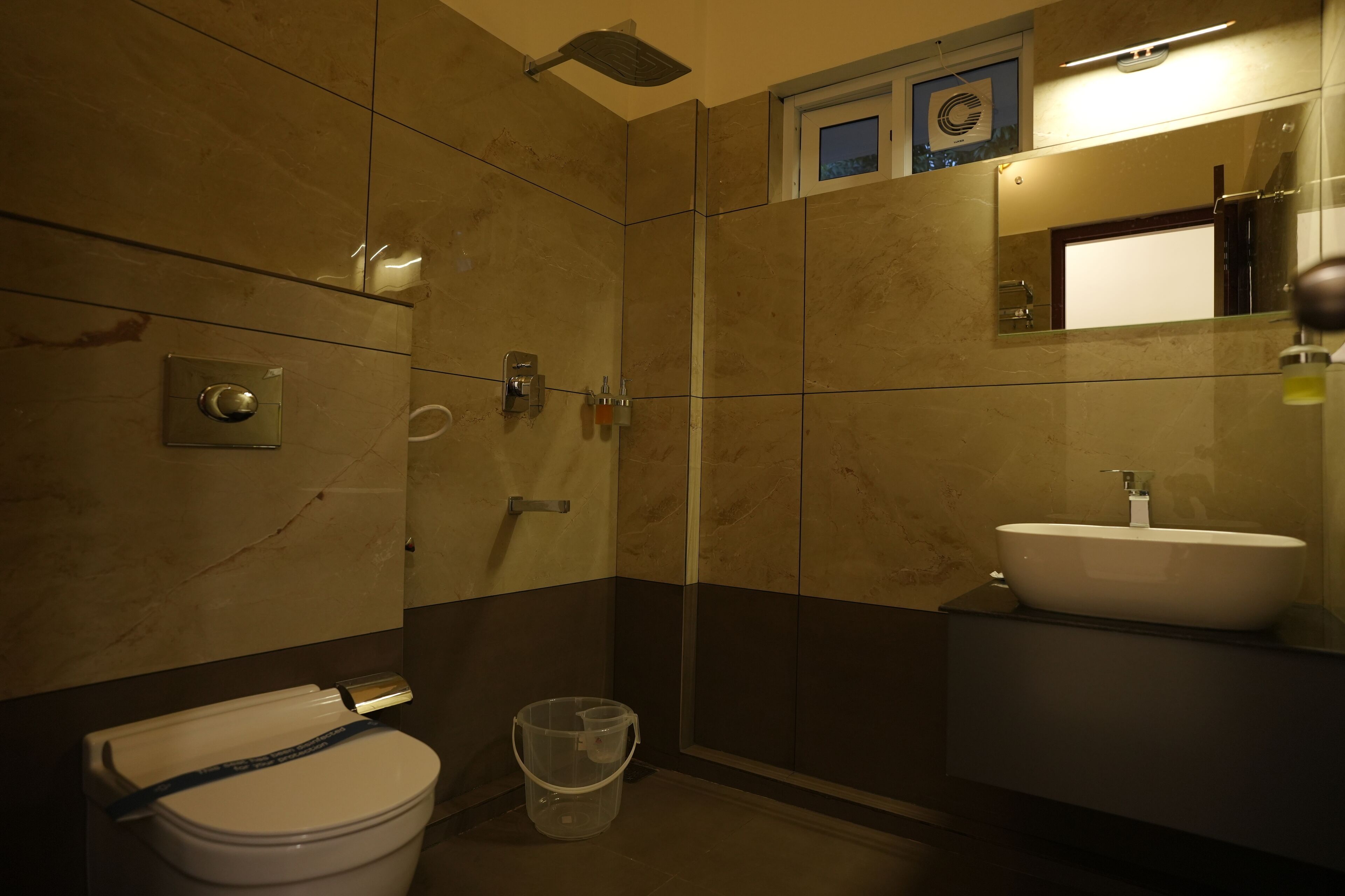 A bathroom with a toilet, shower, and sink.