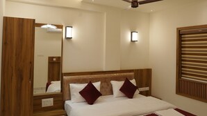 Een moderne slaapkamer met een houten bed, een plafondventilator, inbouwverlichting en een grote spiegel.
