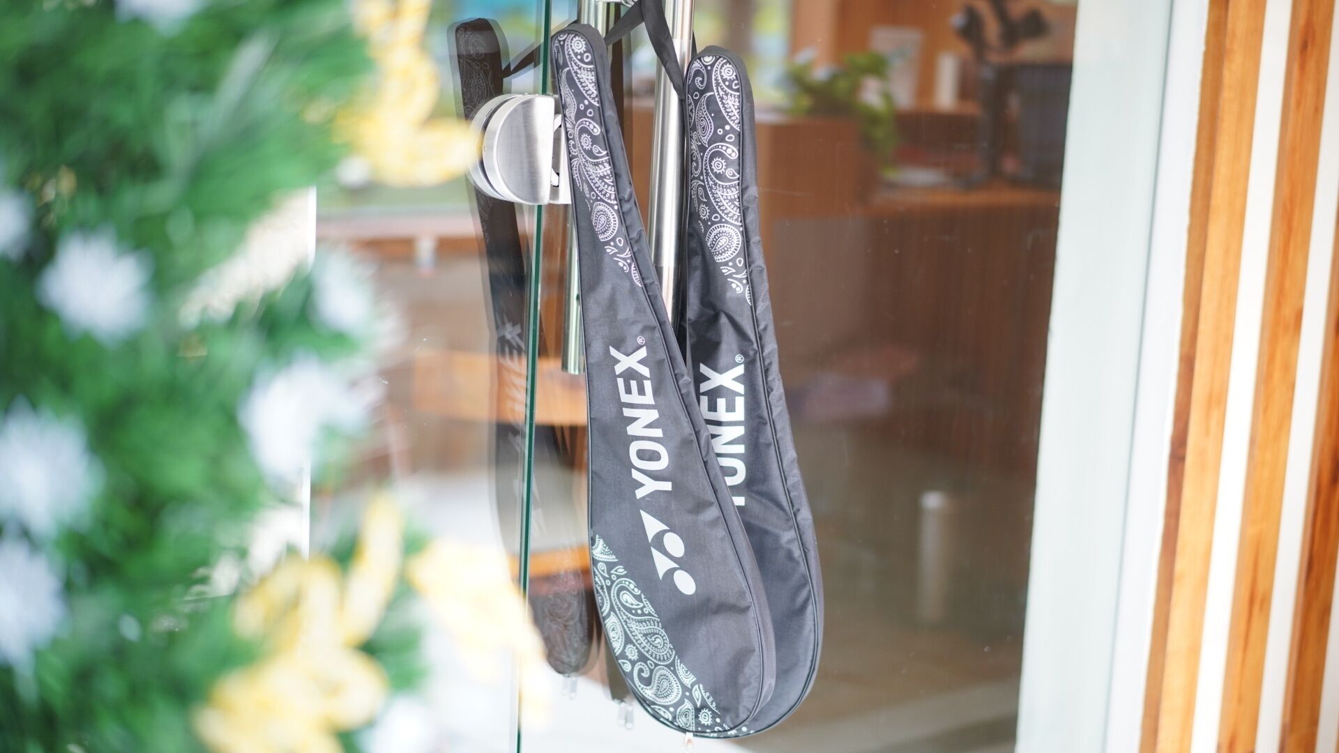 A pair of black and white patterned bags hanging on a door handle.