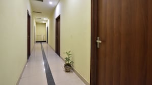 Un pasillo con puertas de madera, una planta en maceta y un cartel con el número 207.
