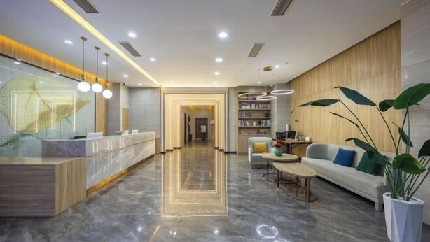 A modern lobby with a reception desk, seating area, and a bookshelf. - Greentree Inn Express Deyang Changjiang Dong Road (Deyang)