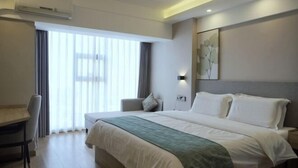 A hotel room with a large bed, a desk, a chair, and a window with curtains. - Greentree Inn Express Deyang Changjiang Dong Road (Deyang)