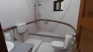 Een douche, handdoeken, zeep, toiletpapier