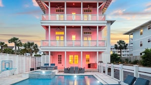 A multi-story building with a pool, outdoor seating, and a balcony. - Sand Volleyball Court w/ Pool and Views (Santa Rosa Beach)