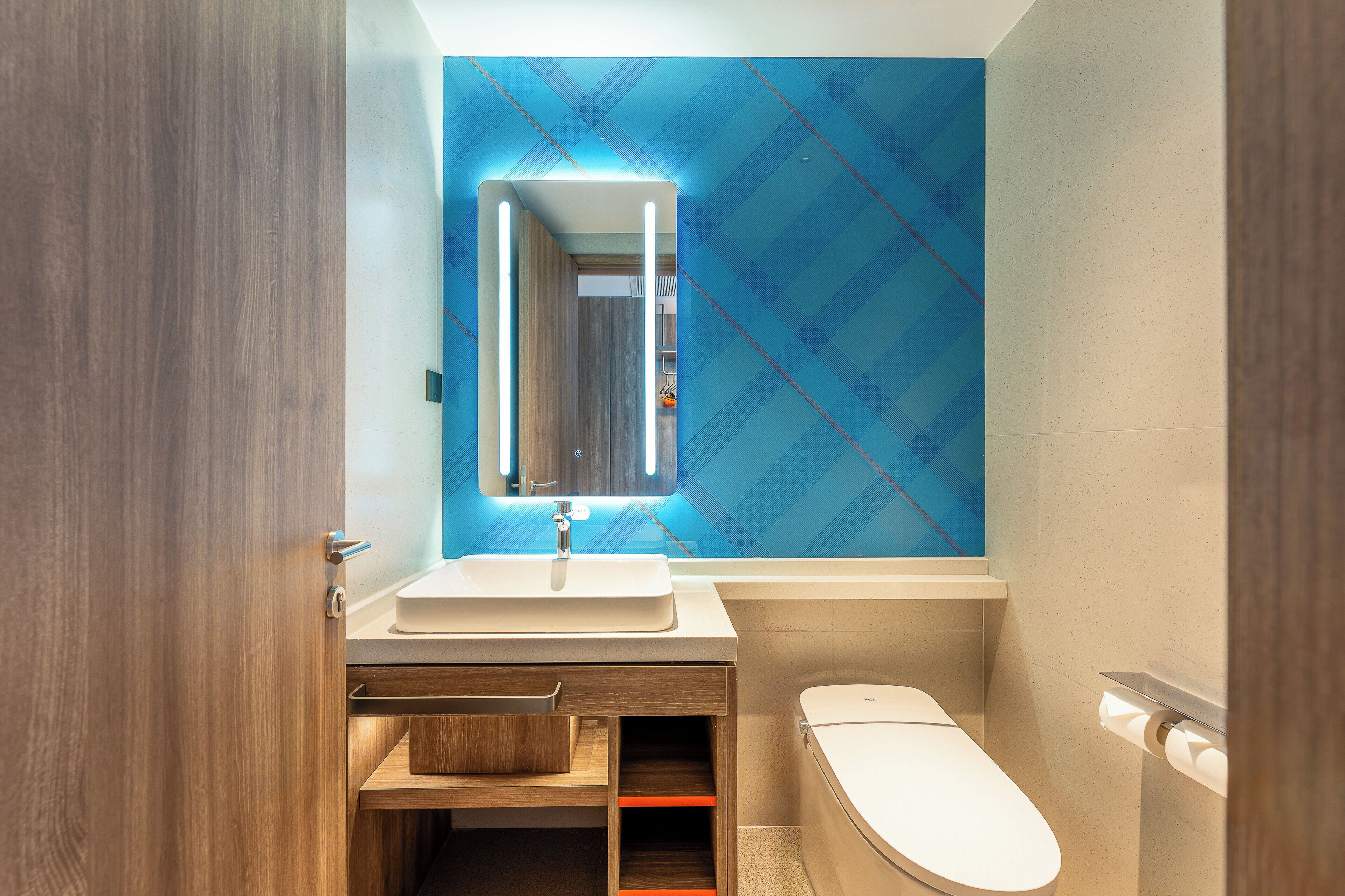 Un bagno moderno con un mobile bagno in legno, un lavandino bianco e un water.