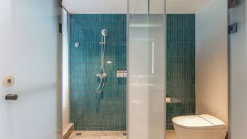 Un bagno moderno con box doccia in vetro, un water e una parete rivestita di piastrelle.
