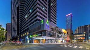 Een Holiday Inn Express hotel met een modern design, gelegen in een stedelijk gebied met hoge gebouwen.
