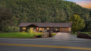 A two-story house with a sloped roof, a brick exterior, and a front entrance with a covered porch. - Bear Paw Cottage- 12 Mins To Seneca Rocks 3 Bedroom Cottage (Seneca Rocks)