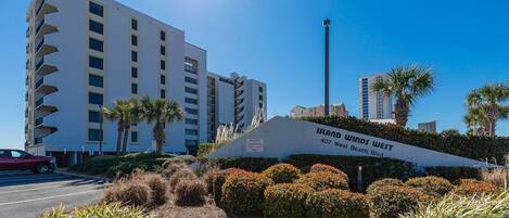 Un edificio moderno con un letrero que dice "Island Winds West 407 West Beach Blvd."
