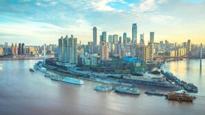 A city skyline with modern high-rise buildings and a waterfront area with boats. - WE HOTEL (Chongqing)