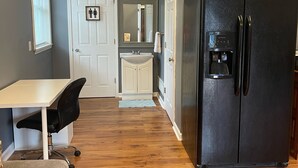 A compact kitchen with a black refrigerator, a white sink, and a small countertop.