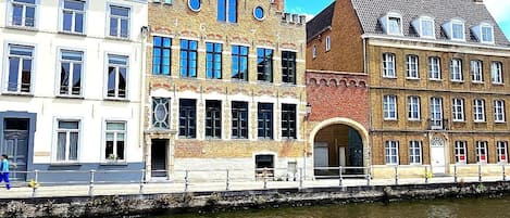 A canal-side view of historic buildings with a clear sky.