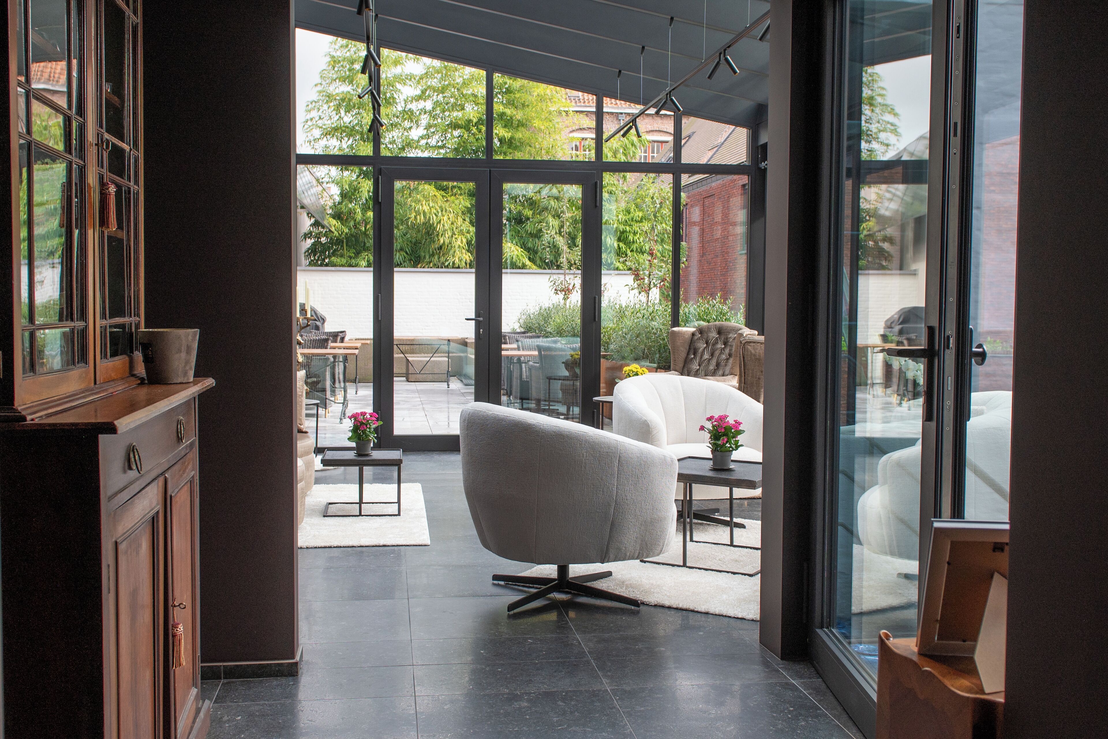 Un intérieur moderne avec une grande porte vitrée donnant sur un patio extérieur.