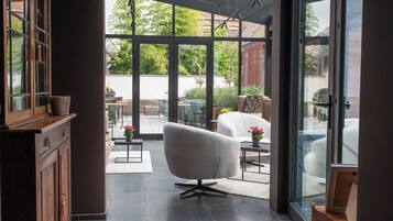Un intérieur moderne avec une grande porte vitrée donnant sur un patio extérieur.
