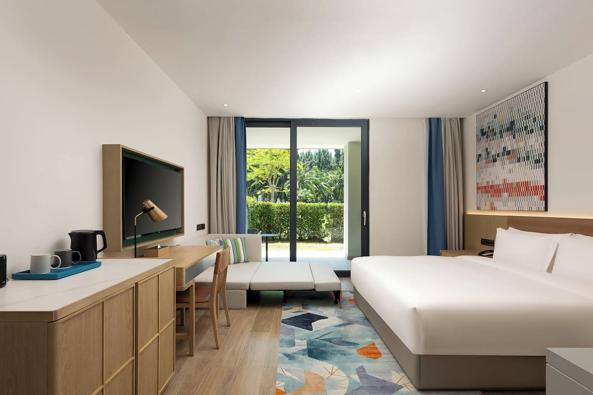Una habitación de hotel con cama, escritorio, silla y televisor.