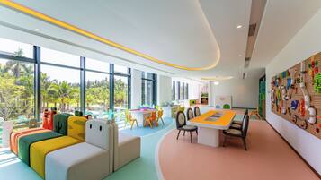 A modern children's play area with colorful furniture, large windows, and a pegboard wall.