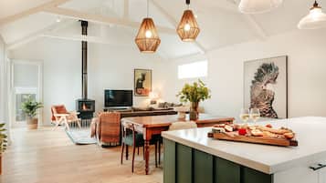 A modern living room with a fireplace, wooden furniture, and a dining area with a large island.
