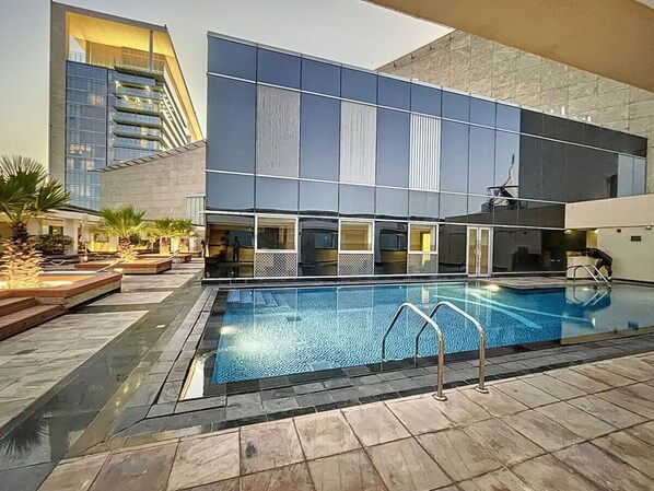 A swimming pool with a modern building in the background.