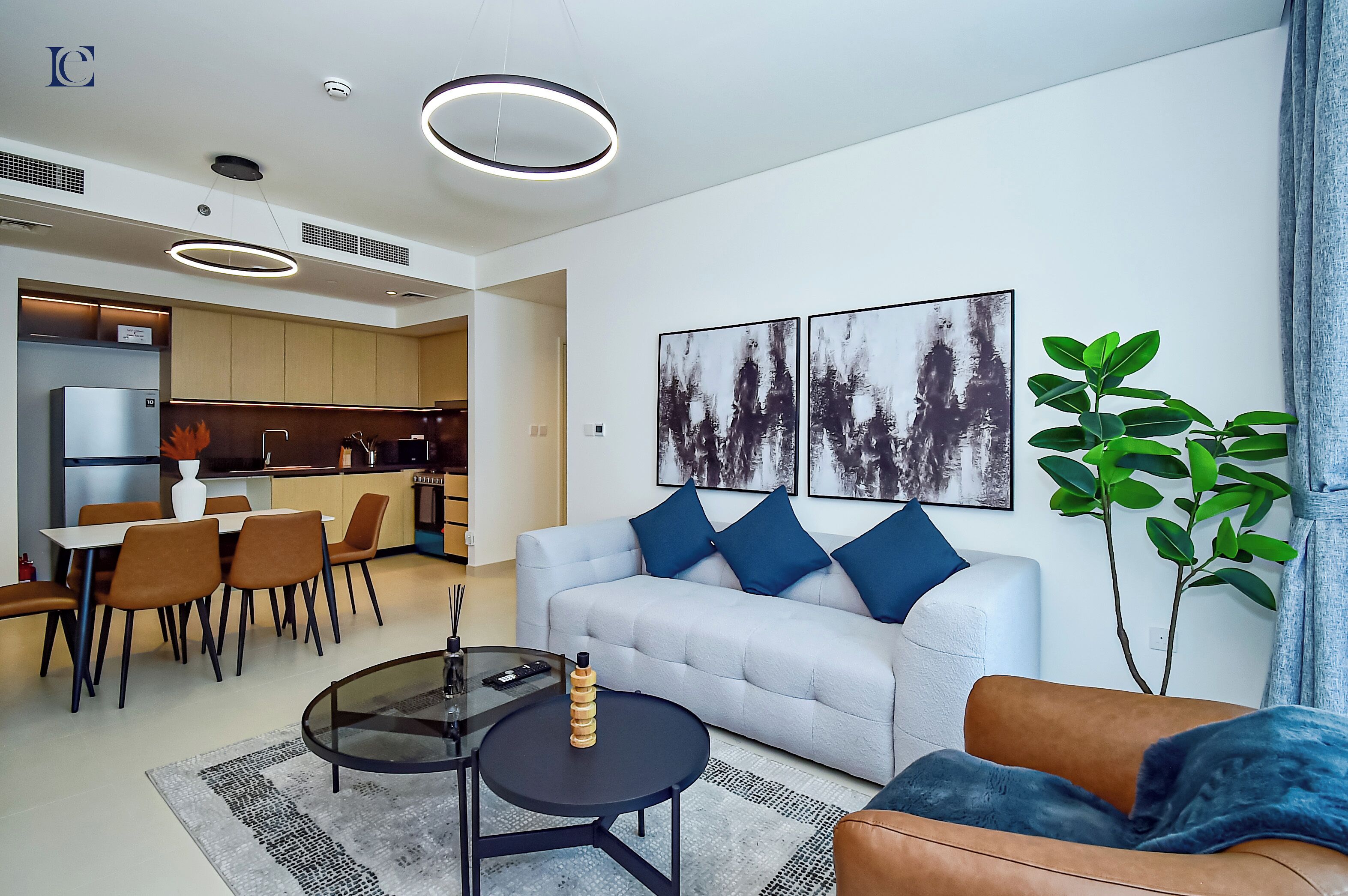 A modern living room with a sofa, coffee table, and dining area.