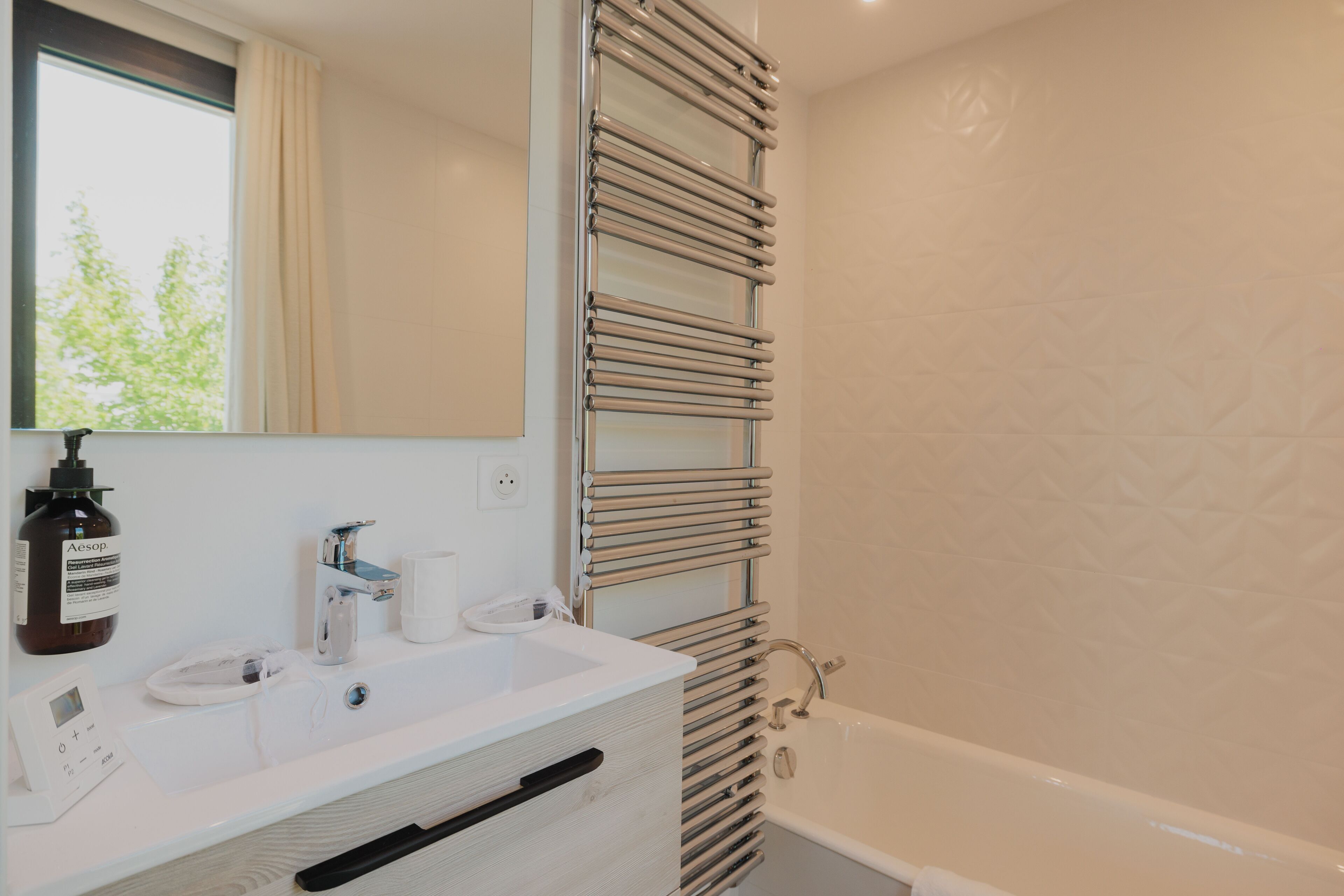 Ein modernes Badezimmer mit Waschbecken, Spiegel und Handtuchhalter.