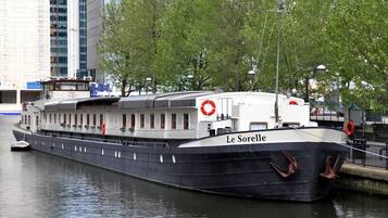 A large, stationary boat named 'Le Sorelle' docked at a port with a cityscape in the background.