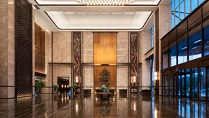 A spacious lobby with a polished marble floor, a central reception desk, and a large chandelier. - Wyndham Huaihua South (Huaihua)