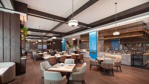 A modern restaurant with high ceilings, pendant lighting, and a central bar area. - Wyndham Huaihua South (Huaihua)