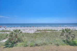 Een strand met parasols en mensen.