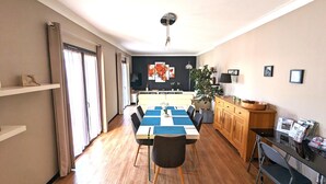 A modern living room with a dining area, wooden flooring, and a large window with curtains. - Appt 3 stars, view on bassin de Thau Terr 30 m² Pets accepted (Mèze)