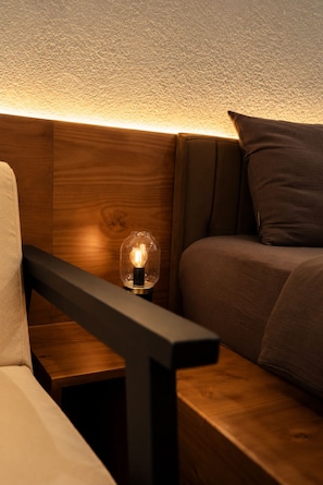 Un divano moderno con una testata in legno e una lampadina su un tavolino.