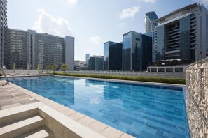 A swimming pool with a cityscape in the background. - Enticing 2BR Apartment in Reva Residences, Business Bay by Deluxe Holiday Homes (Dubai)